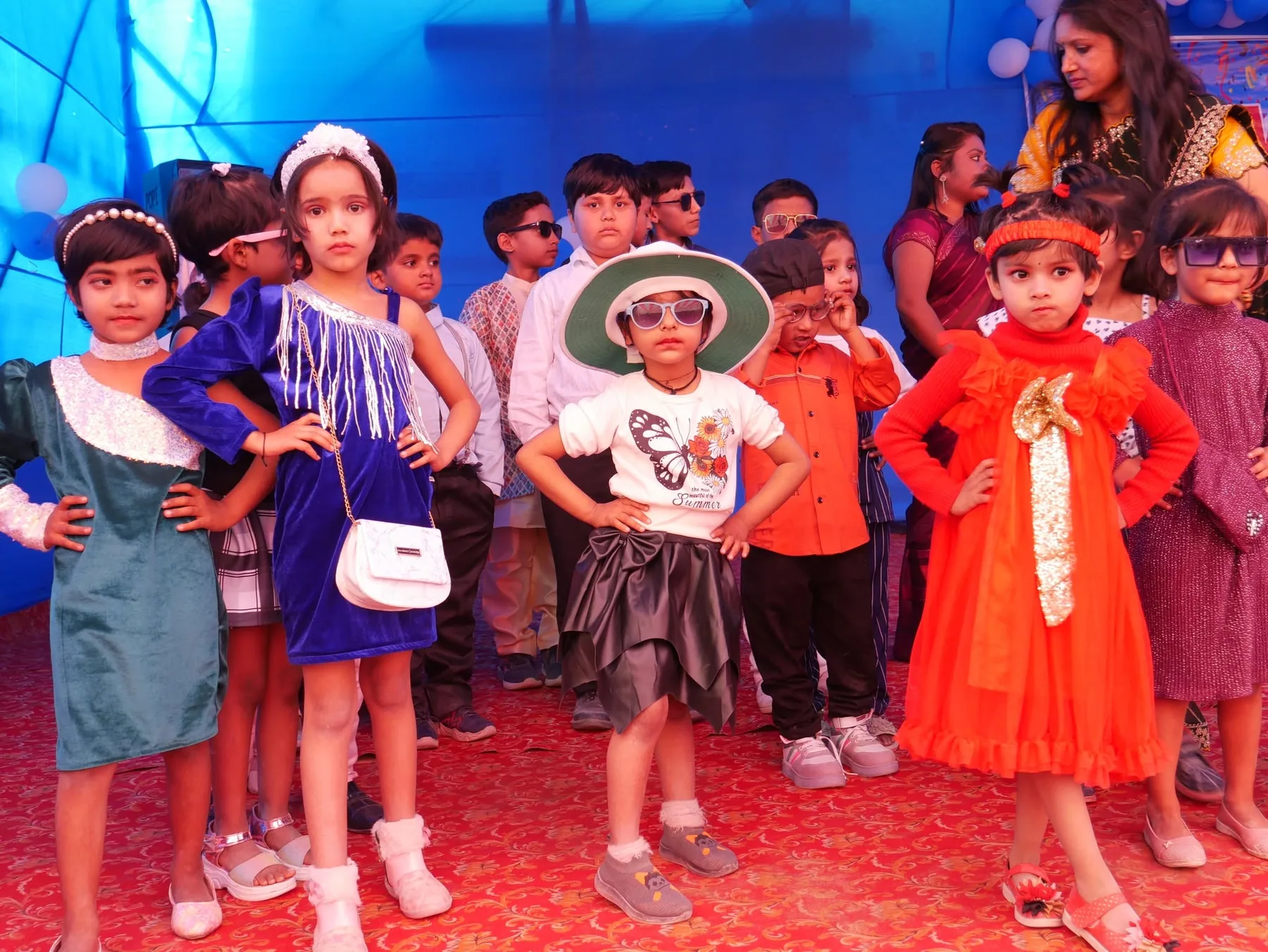 Children in costume posing together on stage during a school performance